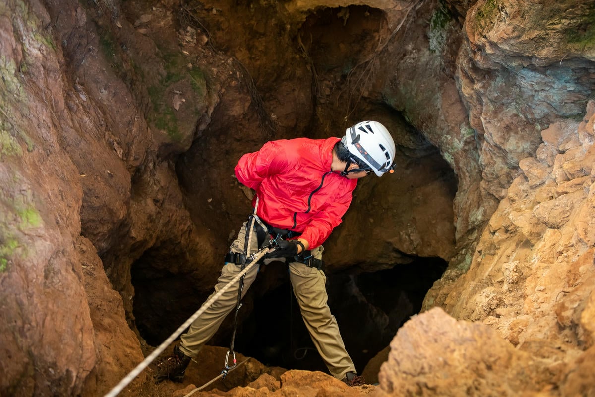 spéléologie initiation, homme qui descend dans un gouffre